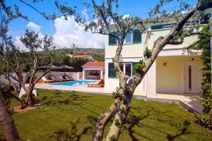 a house with a yard with a swimming pool at VILLA STOZAK, private heated pool, cinema room and sauna, 7 km from beach in Tugare