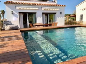 a swimming pool in front of a house at Villas Empúries, Garden & Private Pool in Sant Martí d'Empúries