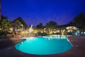 a swimming pool at night with a fountain at Labadi Beach Hotel in Accra