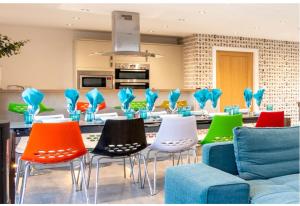 a living room with colorful chairs and a kitchen at Captivating 4-Bed House in Lincoln in Lincoln