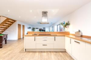 a kitchen with white cabinets and wooden counter tops at Lincoln 4-Beds Sleeps 13 Hot Tub & Pet Friendly in Lincoln