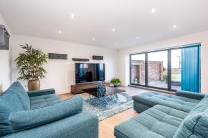 a living room with two blue couches and a tv at Captivating 4-Bed House in Lincoln in Lincoln