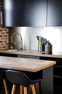 a kitchen with a sink and a wooden counter top at Appart Cosy entre vieux port et marché central in La Rochelle