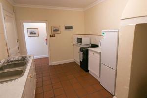 a kitchen with a sink and a white refrigerator at De Kothuize 7 in Graaff-Reinet