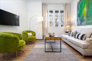 een woonkamer met een bank en 2 groene stoelen bij Genteel Home Recaredo in Sevilla