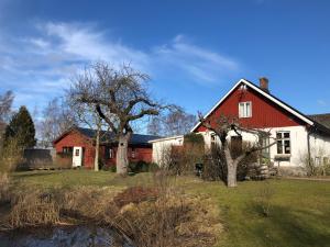 a red and white house with trees in the yard at Villa Maria Garden Cottages, Helsingborg in Helsingborg
