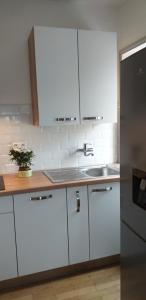 La cuisine est équipée de placards blancs et d'un réfrigérateur en acier inoxydable. dans l'établissement AU 13 : FENETRES SUR ARROMANCHES, à Arromanches-les-Bains