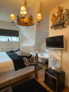 a bedroom with a bed and a bathroom with a sink at Olivia House in Porthcawl