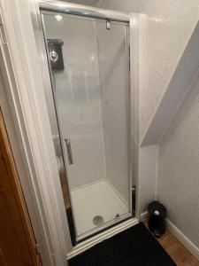 a shower with a glass door in a bathroom at Olivia House in Porthcawl