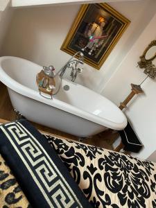 a white tub in a bathroom with a picture on the wall at Olivia House in Porthcawl