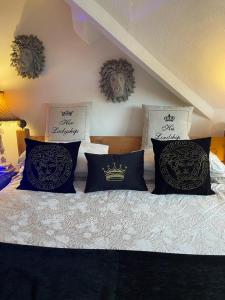 a bed with black and white pillows on it at Olivia House in Porthcawl