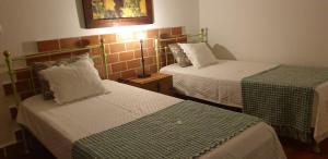a hotel room with two beds with green and white sheets at Herdade Do Rio Torto in Portel
