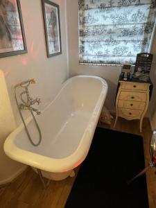 a bath tub in a bathroom with a sink at Olivia House in Porthcawl