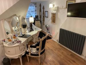 a dressing room with a vanity with mirrors at Olivia House in Porthcawl