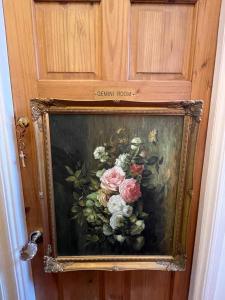 a painting of a vase of flowers on a door at Olivia House in Porthcawl