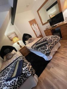 a bedroom with two beds and a mirror on the wall at Olivia House in Porthcawl
