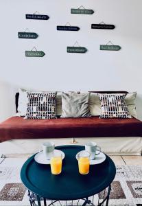 - une table basse avec 2 tasses et du jus d'orange sur un canapé dans l'établissement Chez Marie, à Lyon