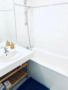 Baño blanco con lavabo y bañera en Chez Marie, en Lyon