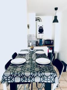 Chez Marie في ليون: مطبخ مع طاولة مع صحون وكراسي