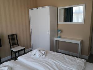 een slaapkamer met een bed, een stoel en een spiegel bij Die Remise Kolibri RE-05 in Stolpe