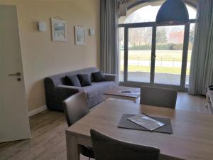 a living room with a table and a couch at Die Remise Oleander RE-06 in Stolpe