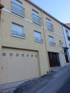 Edificio de ladrillo aige con dos puertas y ventanas de garaje en Hotel Arago, en Cerbère