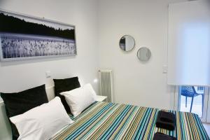 sypialnia z łóżkiem z kołdrą w paski w obiekcie Stunning Cozy Apartment in Athens w Atenach