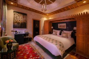 Un dormitorio con una cama grande y una silla. en Elegancia Riad Boutique & SPA, en Marrakech 164 fotos más