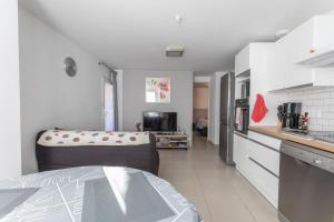 a kitchen with a couch in the middle of a room at L'écureuil dans La vieille maison centre ville d'Embrun in Embrun