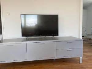 a white entertainment center with a flat screen tv on it at Skyloft Apartment Feldkirch in Feldkirch