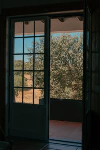 una puerta abierta con vistas a un árbol exterior en Herdade da Caniceira en Ervedal