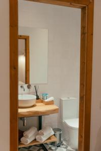 a bathroom with a sink and a toilet and a mirror at Herdade da Caniceira in Ervedal