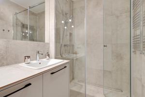a bathroom with a sink and a glass shower at 4 Seasons Jelitkowo + Beach in Gdańsk
