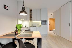 a kitchen and dining room with a table and chairs at 4 Seasons Jelitkowo + Beach in Gdańsk +23 photos