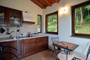 a kitchen with wooden cabinets and a table and chairs at Country House Arborea in Bagnoregio