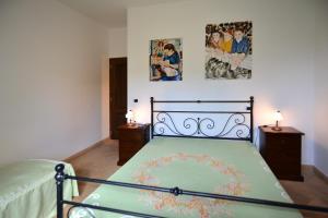 a bedroom with a bed and two pictures on the wall at Country House Arborea in Bagnoregio +11 photos