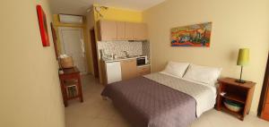 a small bedroom with a bed and a kitchen at Vasilis Studios in Kiveri