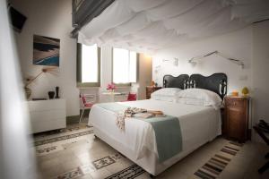 a bedroom with a large white bed with a canopy at La Moresca Maison De Charme in Marina di Ragusa