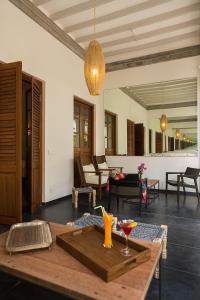 una sala de estar con una mesa con una bebida. en La Villa, en Pondicherry