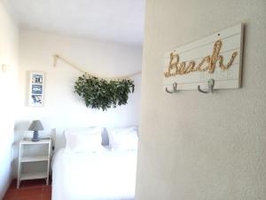 a bedroom with a bed and a sign on the wall at Troia Beach Getaway in Troia