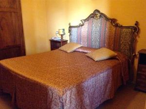 a bedroom with a bed with a large headboard at Albergo Ristorante Da Carlino in Castelnuovo di Garfagnana