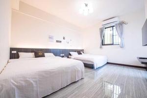 1 Schlafzimmer mit 2 Betten und einem Fenster in der Unterkunft 樂洋洋民宿 in Magong