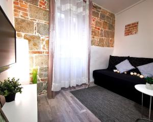 a living room with a black couch and a brick wall at Apartment Herc in Split
