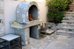 a stone pizza oven with a fire in it at Luxury Apartment Goja with private pool and Jacuzzi near Dubrovnik in Ivanica