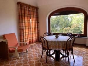 uma sala de jantar com uma mesa e cadeiras e uma janela em Villa Catenacci Anacapri em Anacapri