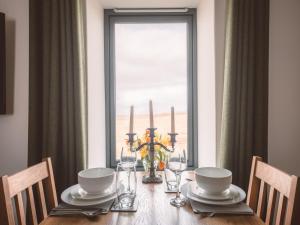 a dining room table with a view of a window at Monkstadt No 6 -Jessie's Hideaway in Portree