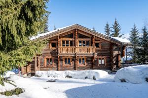 a log cabin with snow in front of it at Madame Vacances Chalet Elliot Ouest in La Tania