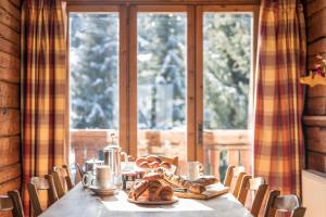 a table with bread and cookies on it in front of a window at Madame Vacances Chalet Elliot Ouest in La Tania +5 photos