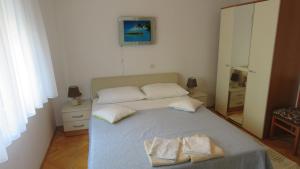 1 dormitorio con 1 cama con 2 toallas en Rooms Kasalo, en Split