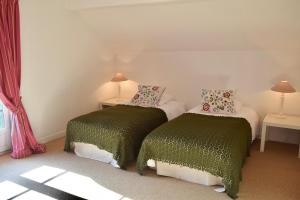 イヴレ・レヴックにあるCottages de Château de Vauxのベッドルーム1室(ベッド2台、緑と白のシーツ付)